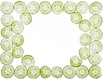 Cucumber slices on a white background by Carola Schellekens