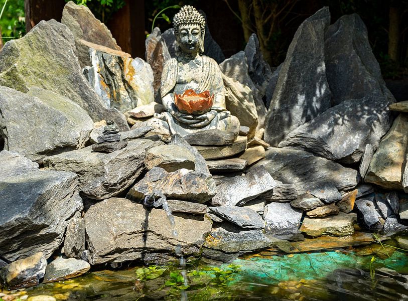 Statue de Bouddha dans une rocaille japonaise avec étang de jardin par Animaflora PicsStock