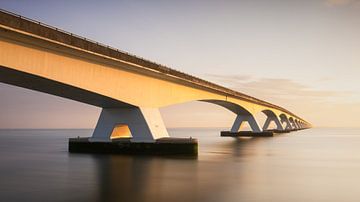 Verbinding in Gouden Licht: Zeelandbrug in de Ochtendzon van Hevonax Photography