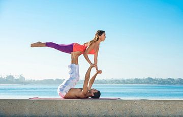 A couple in an acrobatic yoga position on the beach at San Diego by BeeldigBeeld Food & Lifestyle