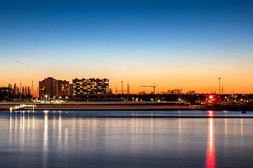 Long exposure van waterbus op de schelde tijdens zonsondergang met skyline van Linkeroever Antwerpen van Daan Duvillier | Dsquared Photography