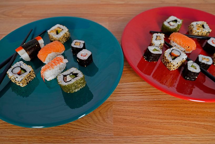 Sushi disposés sur une assiette avec des baguettes. par Babetts Bildergalerie