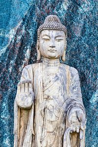 Buddha-Statue vor einer blauen Granitwand