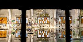 Abandoned hall with graffiti and reflections - art and decay in a lost place by Infinite Decay
