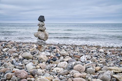 Stenen piramide op het strand met uitzicht op zee. Deense kust. Scandinavisch landschap