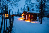 Verlichte houten hut in winterlandschap van Martijn Smeets thumbnail