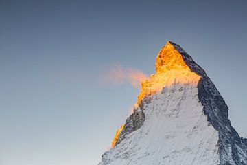 Glowing Matterhorn peak with snow dust in winter