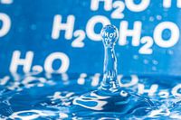 Waterdruppel met blauwe achtergrond met H2O erop