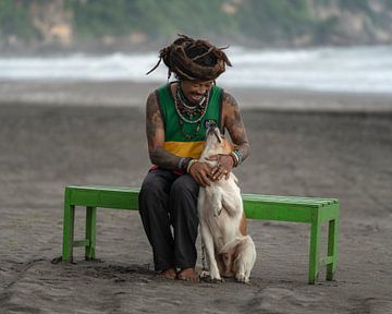Ein Reggae-Mann am Strand mit seinem Hund