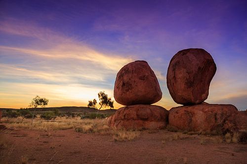 Zonnestralen en Stenen - Devil's Marbles in Gouden Uur met prachtige paars en gouden lucht