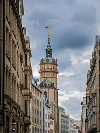 De Nikolaikirche in Leipzig tussen gevels onder de wolken