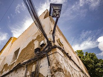 Old building with power cables and street lamp in Ibiza town
