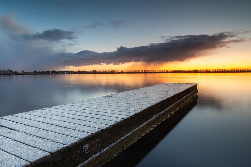 Met sneeuw bedekte steiger in het Meer van Dirkshorn tijdens zonsopkomst. van Bram Lubbers