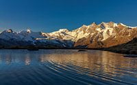 Zonsopkomst op bergtoppen van Saas-Fee bij bergmeer