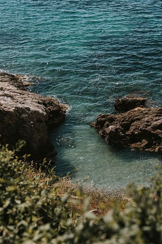 Blick auf Felsformationen und türkisfarbenes Wasser in Ibiza, Spanien von Manon Visser