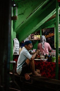 Balinese local geniet van een maaltijd op de markt van Kíen Merk