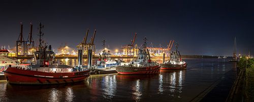 Verlichte sleepboten in de haven bij nacht