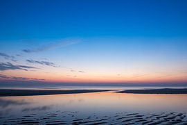 Blauw uur op een spiegelend getijdenstrand van Troy Wegman