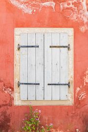 Weiße Fensterläden an einer toskanafarbenen Wand