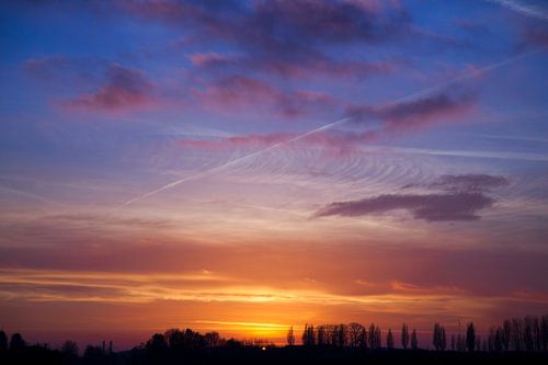 vliegtuigstrepen bij zonsondergang