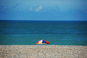 Kleurige parasol aan het strand van Blond Beeld