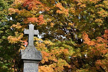 A cross in a cemetery in autumn by Claude Laprise