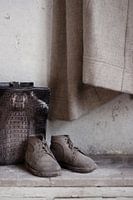 Stilleben mit Kinderschuhen und Tasche in verlassener Villa
