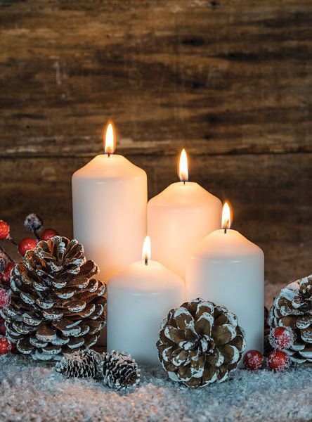 Advent and Christmas candles with natural decoration with wood background by Alex Winter