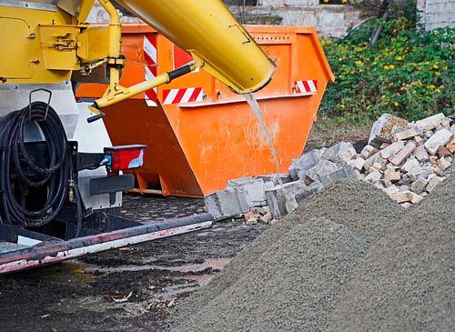 Bouwvoertuigen en -materiaal brengen een betonnen ring aan op een oude graanelevator.