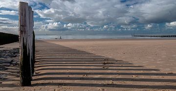 Golfbrekers maken lijnen op het strand