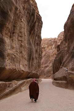 Foto van een Jordanese man die door de kloof van Petra wandelt van Linda Vreeswijk