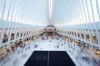 the Oculus in New York van binnen met veel bewegende mensen.
