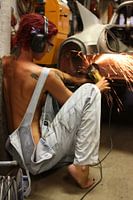 Woman working on sanding her car in the garage 2