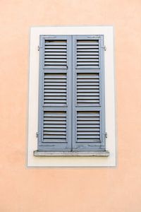Rosa-orange Wand mit blauem Fenster | Italien | Reisefotografie | Pastellfarben von Mirjam Broekhof