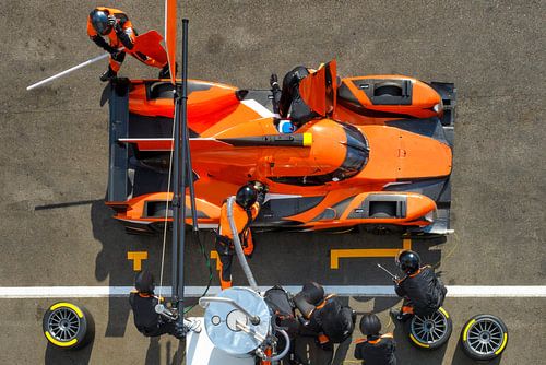 Samenwerking bij de pitstop van een raceauto van bovenaf gezien