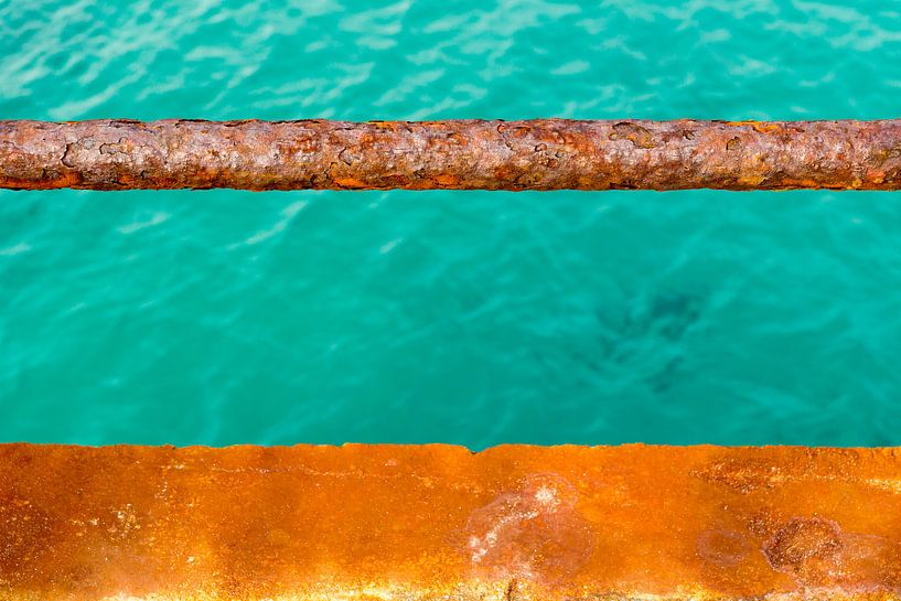 Turquoise water en een roestige kade van Michel van Kooten