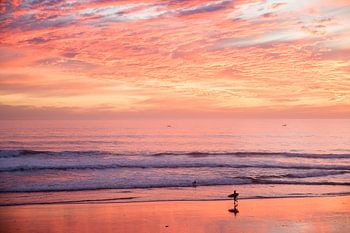 Surfer bij zonsondergang in Taghazout, Marokko