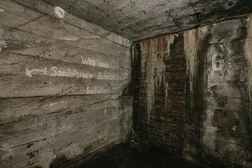 Oude encryptie in een verlaten WWII bunker. van Het Onbekende
