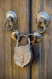 Antikes Schmiedeeisen-Vorhängeschloss an einer alten Holztür von Milcho Milev