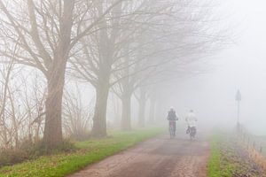 Neblige Landschaft mit zwei Radfahrern