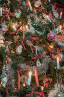 Prachtige antieke kerstballen en kaarsjes in een unieke omgeving van de kerststal met een huiselijke sfeer.
