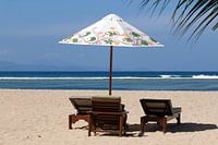 Parasol met ligstoelen op het strand van Sanur op Bali