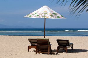 Parasol met ligstoelen op het strand van Sanur op Bali