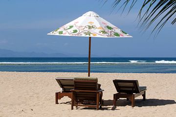 Parasol met ligstoelen op het strand van Sanur op Bali van Maurice de vries