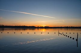 Sonnenaufgang an einem See und Bojen.