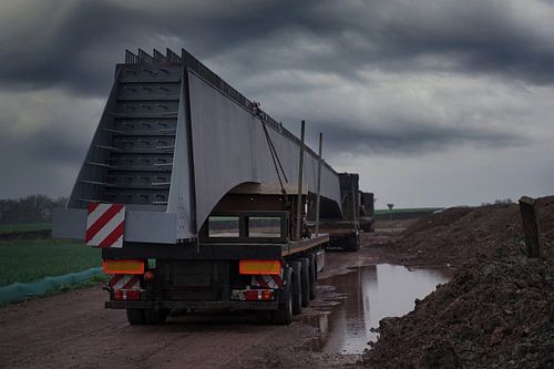 Aankomst van vrachtwagens met brugliggers