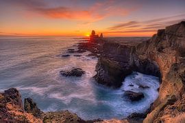 A gentle sunset over rugged cliffs and crashing waves by Judith Kuhn