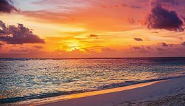 Zonsondergang op het strand met wolken