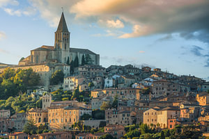 Die Skyline der Bergstadt Todi und die Kirche San Fortunato bei Sonnenuntergang