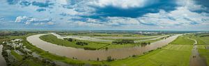 Frühlingslandschaft am Fluss IJssel mit dunklem Himmel darüber